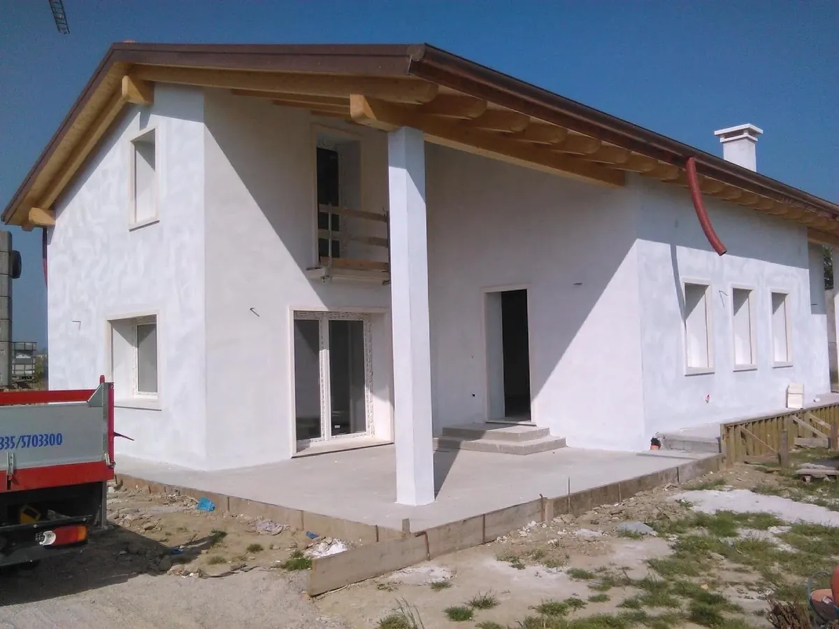 Casa bianca con portico, portefinestre e finestre installate