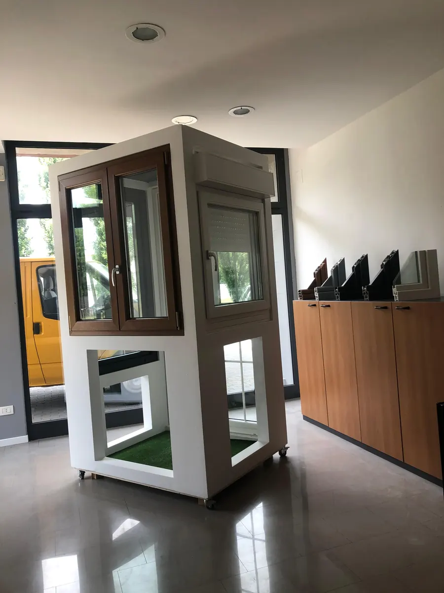 Ambiente espositivo con un modulo di finestre e un mobile con campioni di profilo